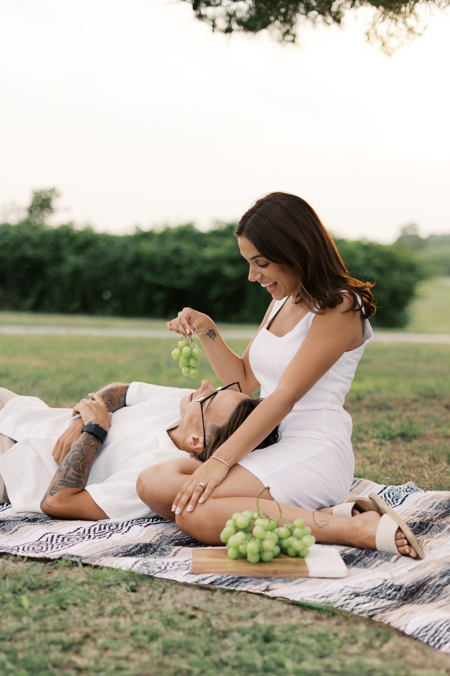 Woman feeding grapes to her fiance at Fort Taber Park in New Bedford, MA.