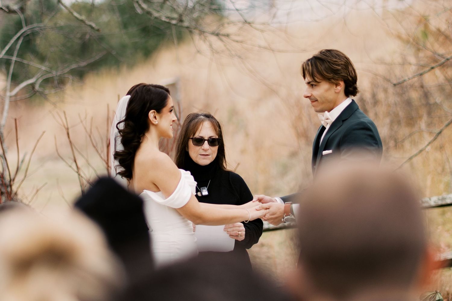 Candid photography of a bride and groom exchanging rings during an intimate winter wedding on the South Coast.