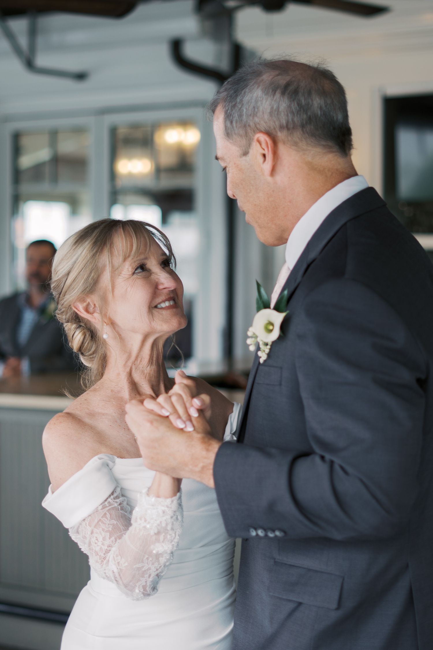 Candid photography of a bride and groom sharing their first dance at a waterfront Rhode Island wedding reception.