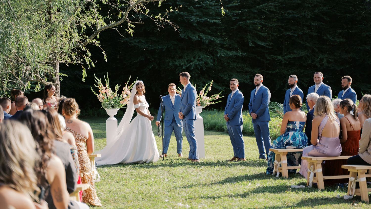 Bride smiling to the crowd while getting married in the sun at Salt River Farm in Marshfield, MA.