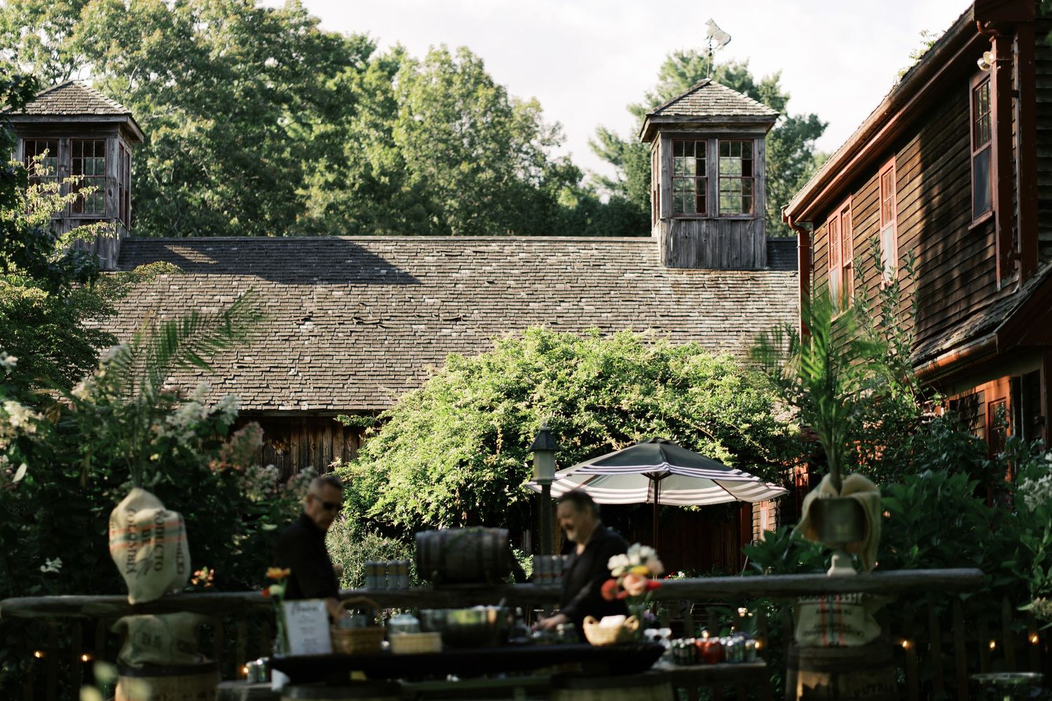 Wide angle shot of the historic weathered barn at Salt River Farm during golden hour, the centerpiece of a Marshfield wedding.