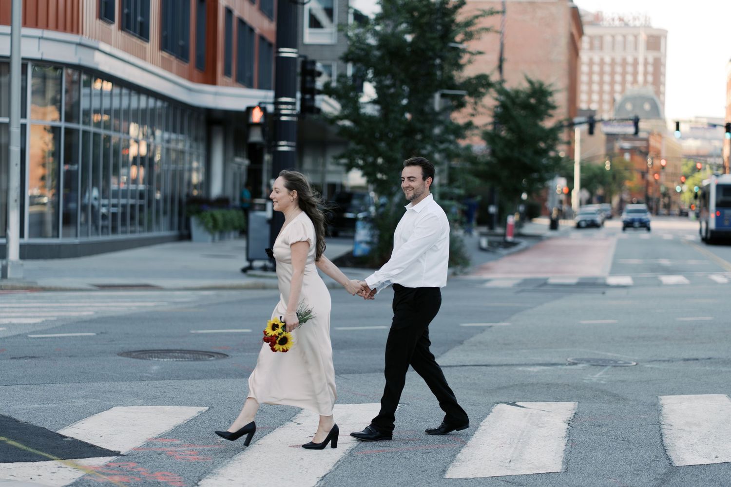 Couple walking through a crosswalk in Providence, RI. This is a part of an engagement shoot at the Michael S. Van Leesten Memorial Bridge.