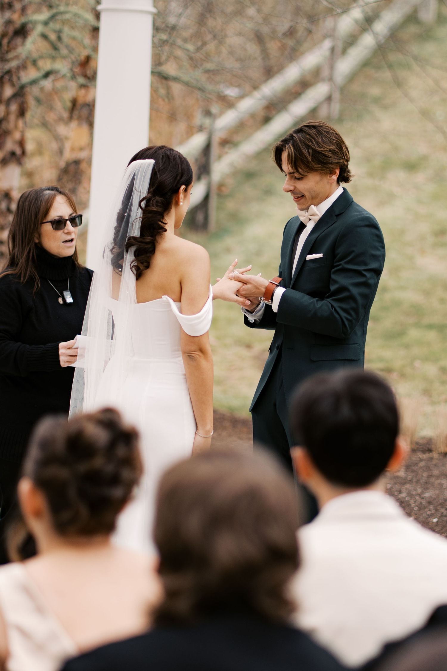 Candid photography of a bride and groom exchanging rings during an intimate winter wedding on the South Coast.