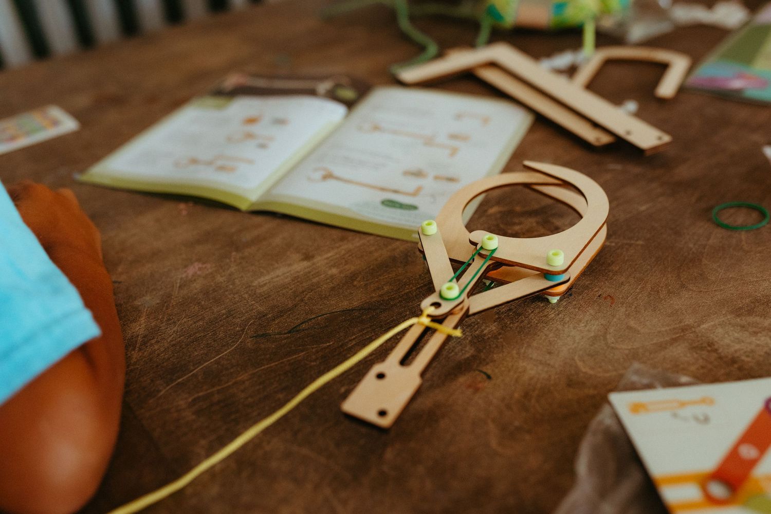 Wooden craft supplies and books laid out on brown surface.