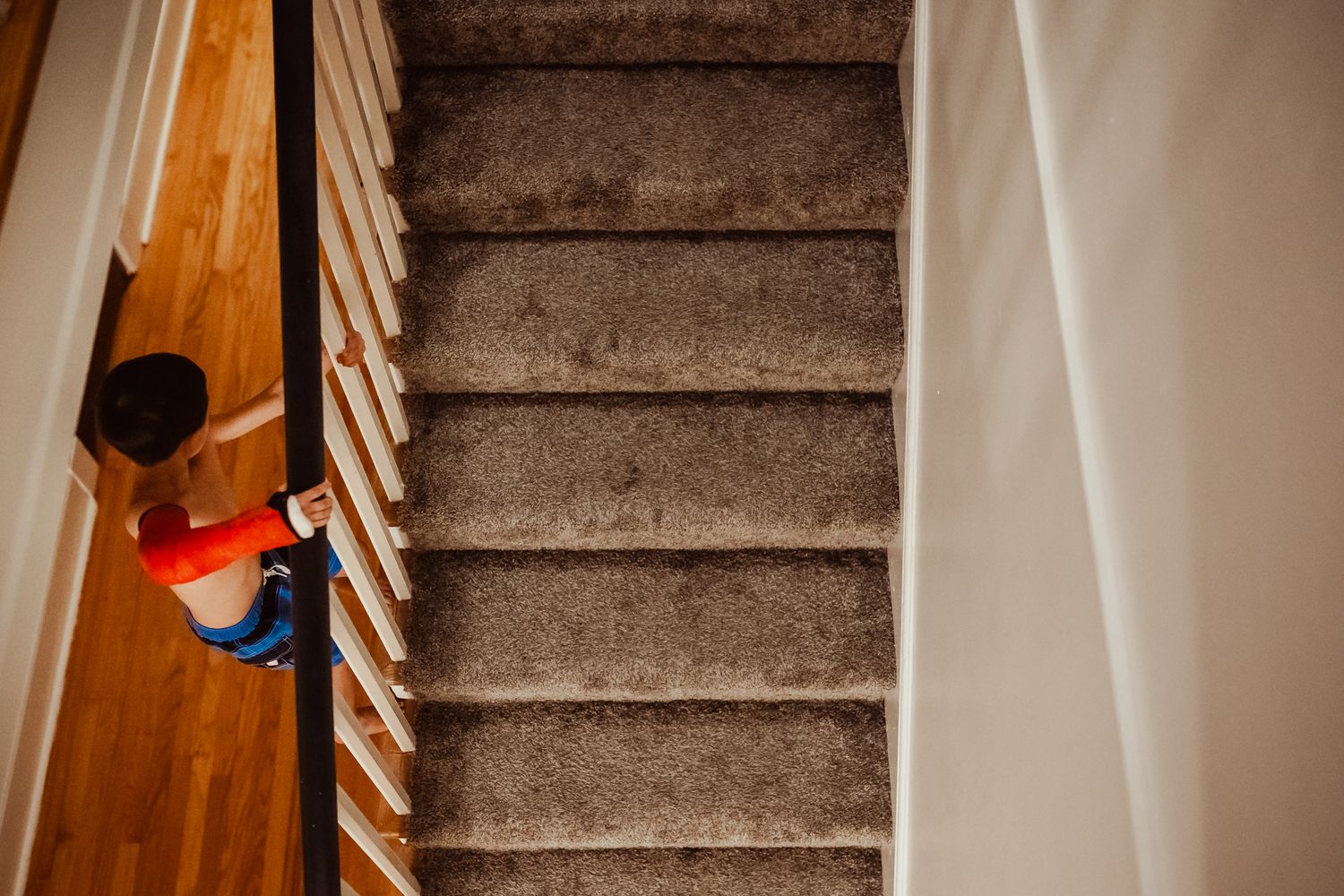 Multiple views of carpeted stairs in a home with wooden railings.