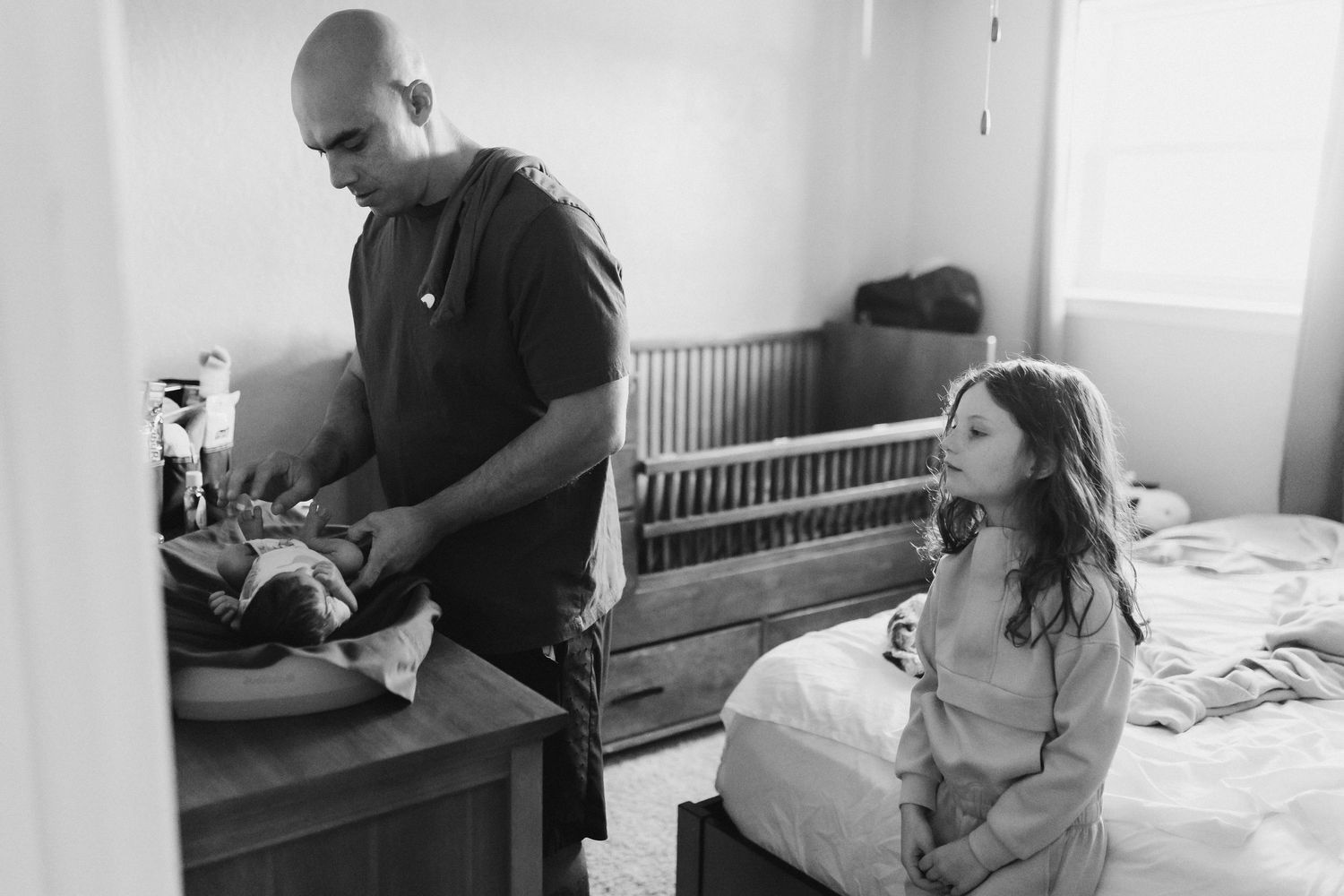 Family members sharing intimate moments in a bright, minimalist room setting.