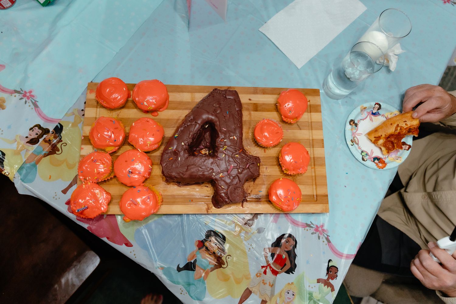 A chocolate number 4 cake with sliced strawberries arranged on a wooden cutting board. In-Home Photography Liz Perez