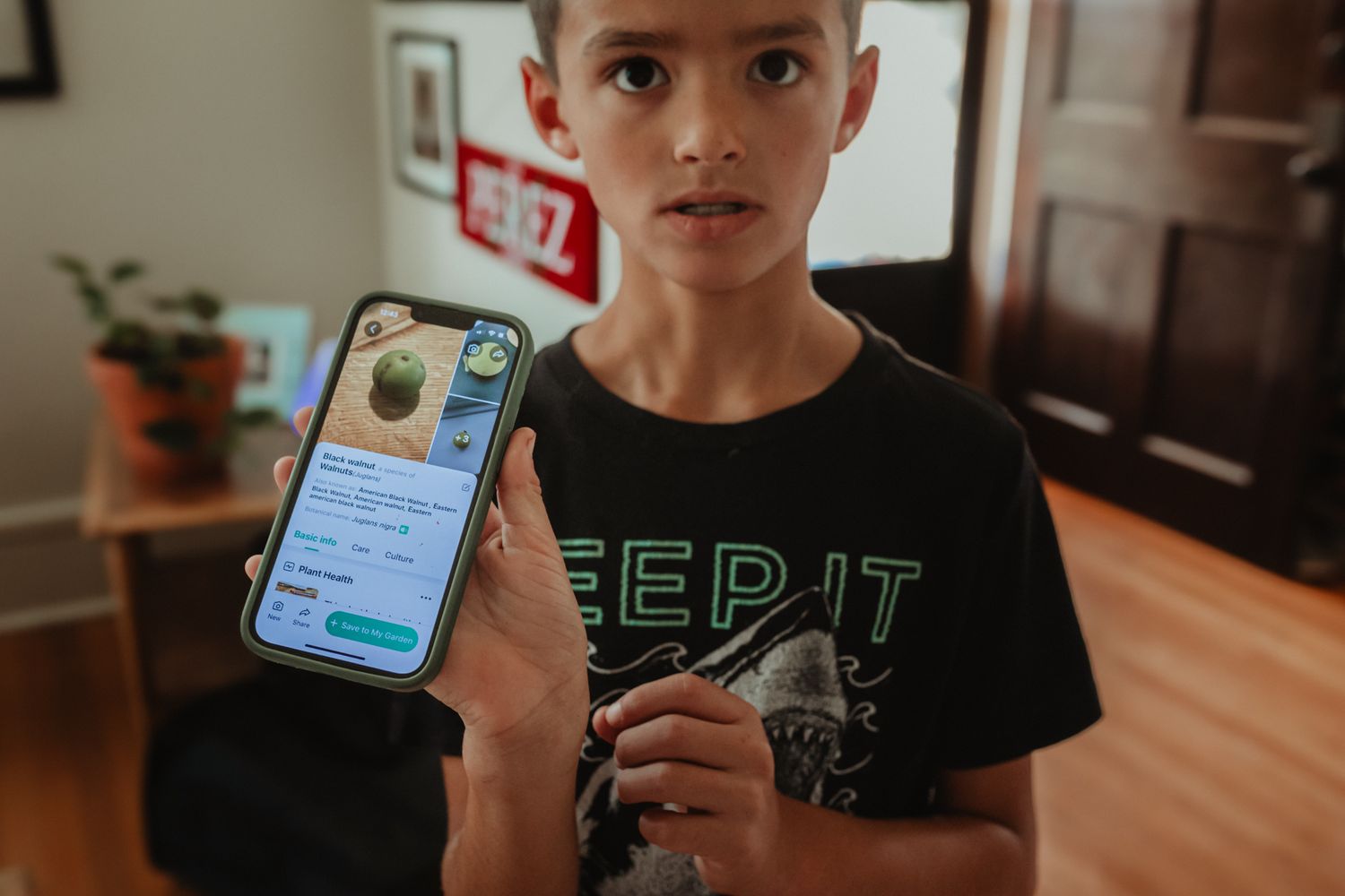 Person holding a mobile device displaying an app interface.
