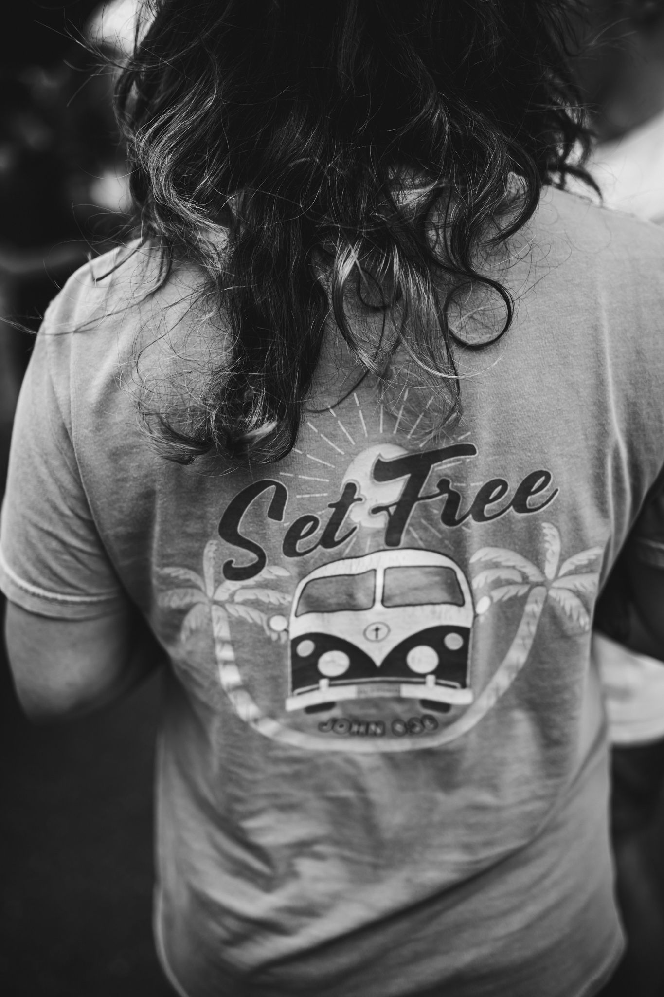 Close up of gray t-shirts with vintage van designs and palm tree graphics. In-Home Photography Liz Perez