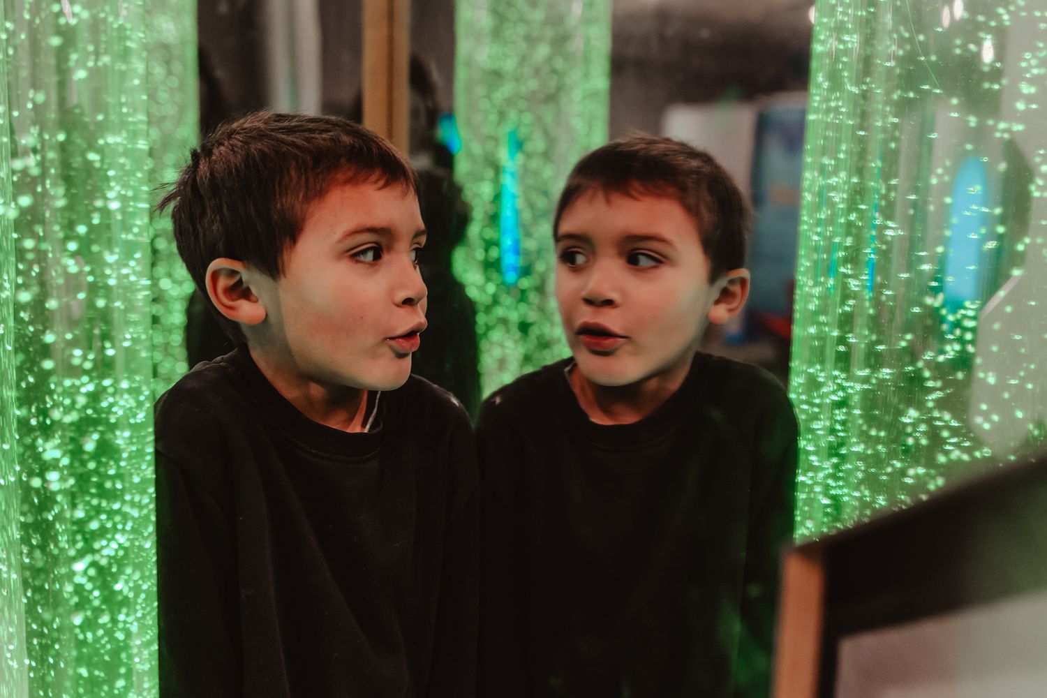 Theatrical scene with green bubble-like lighting effects in the background.