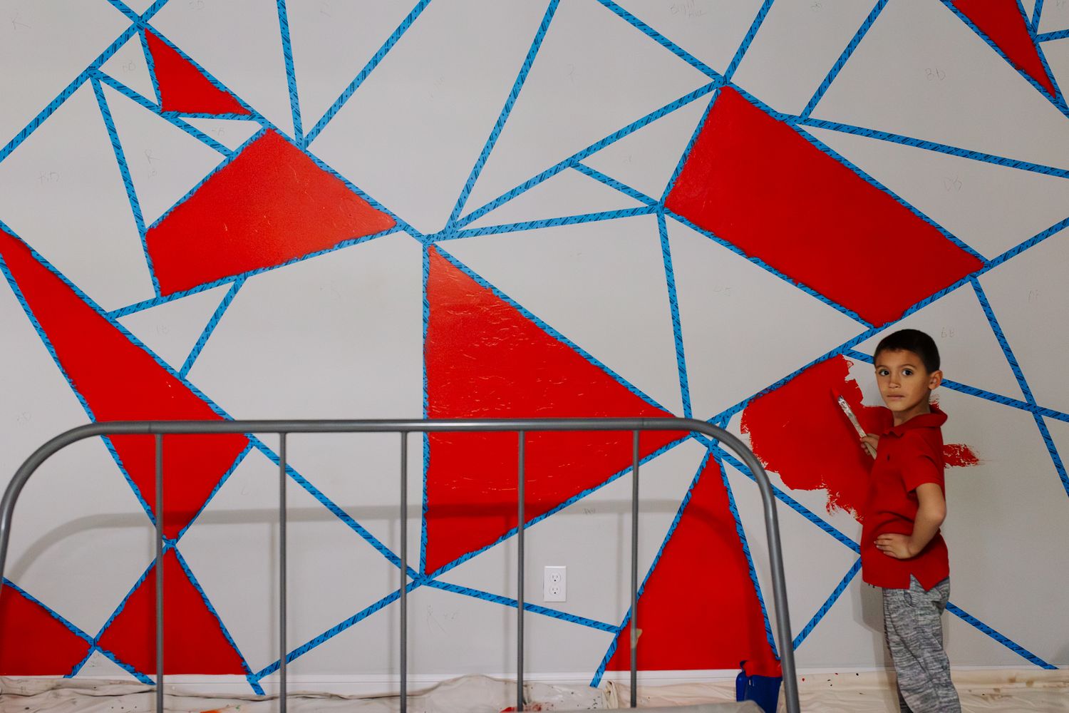 Red triangular flags hang against a blue geometric background creating a striking visual pattern at an event.