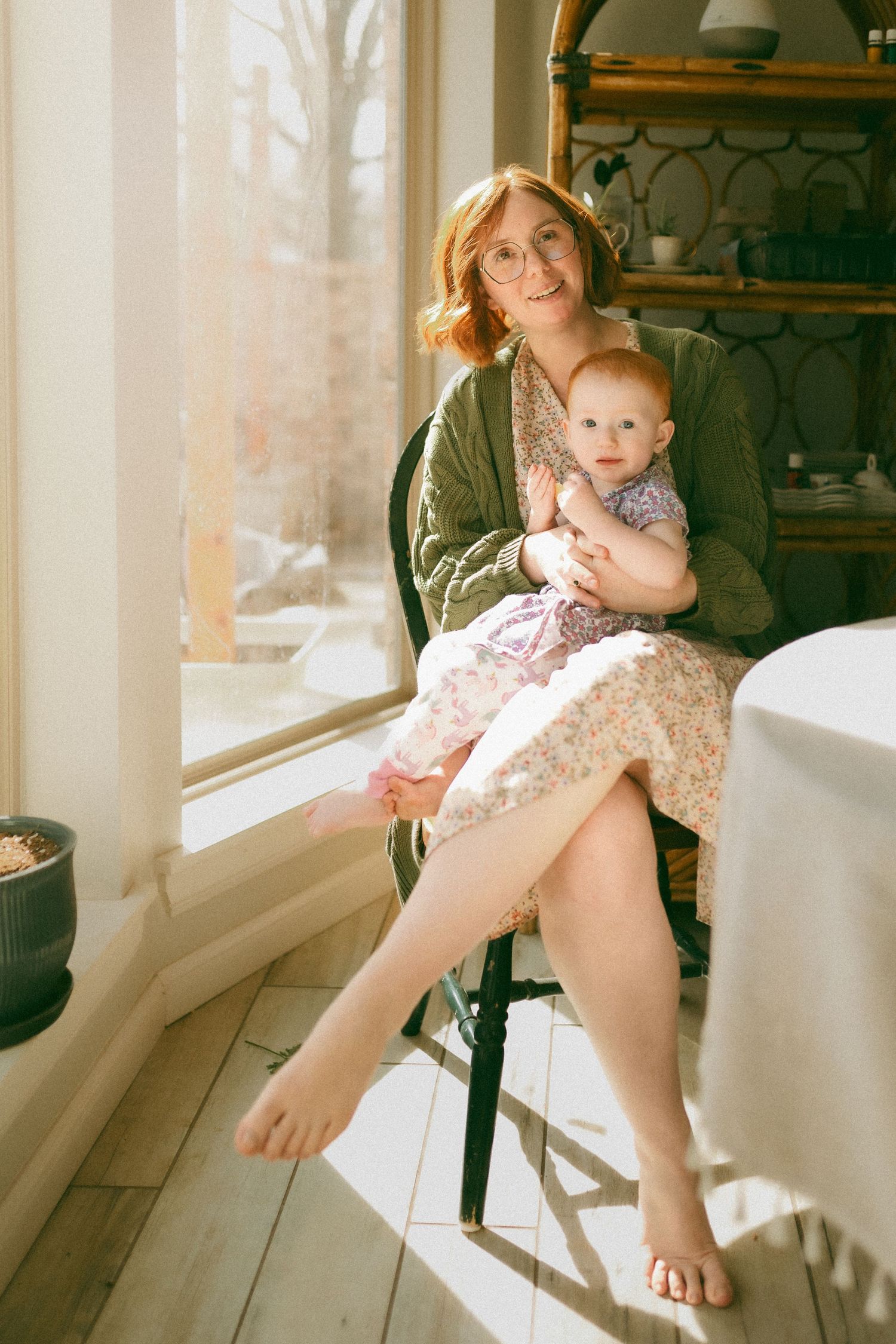 A child sits in a sunlit room near large windows creating a warm, nostalgic atmosphere.
