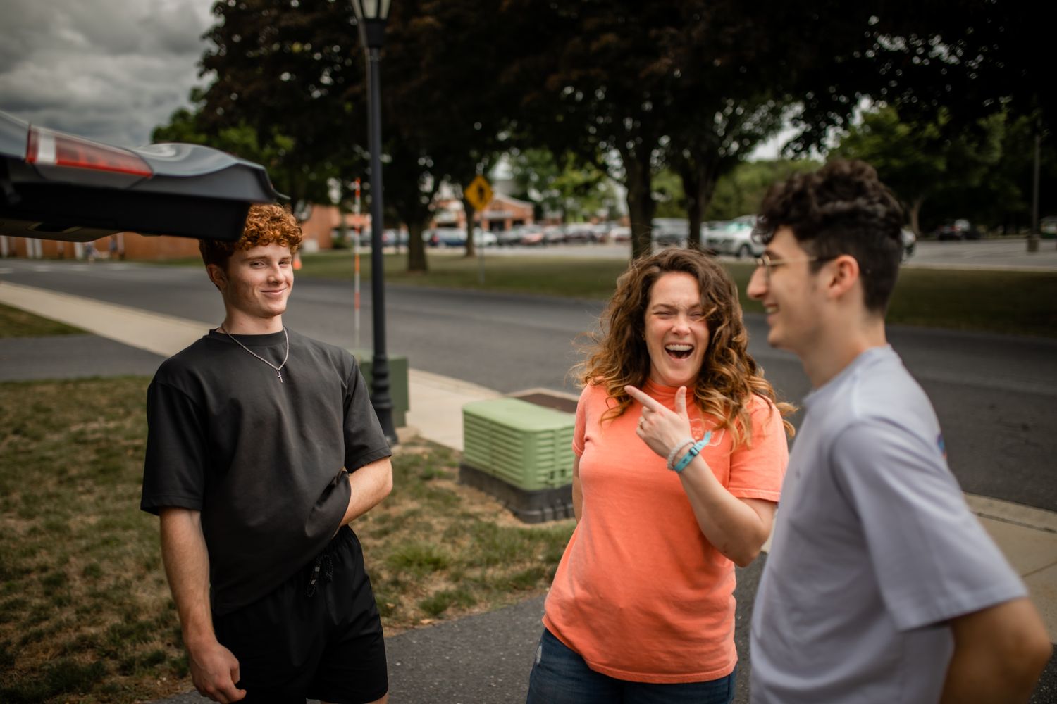 A joyful group conversation taking place on a tree-lined street.