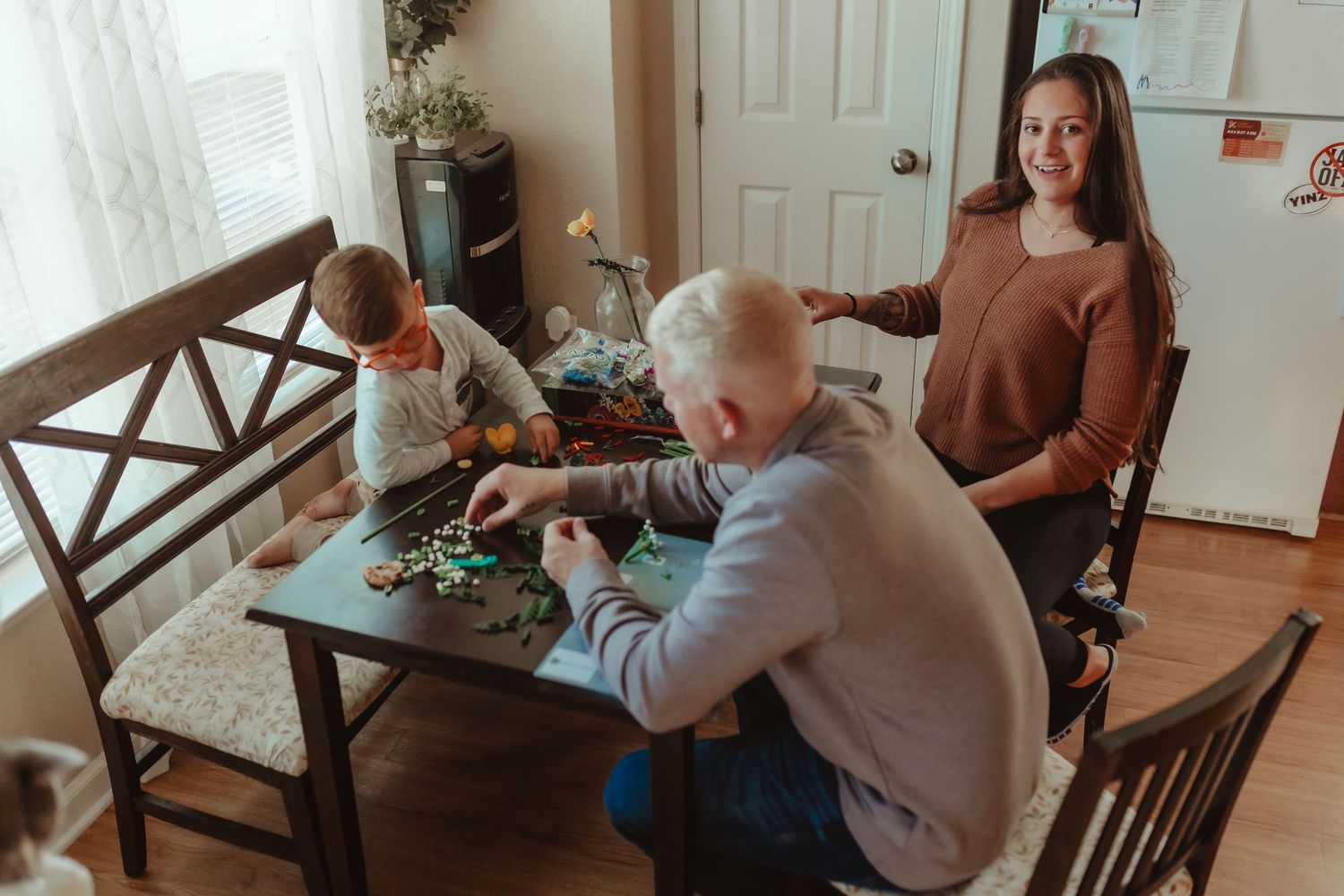 A family gathered around a table engaged in an activity together.