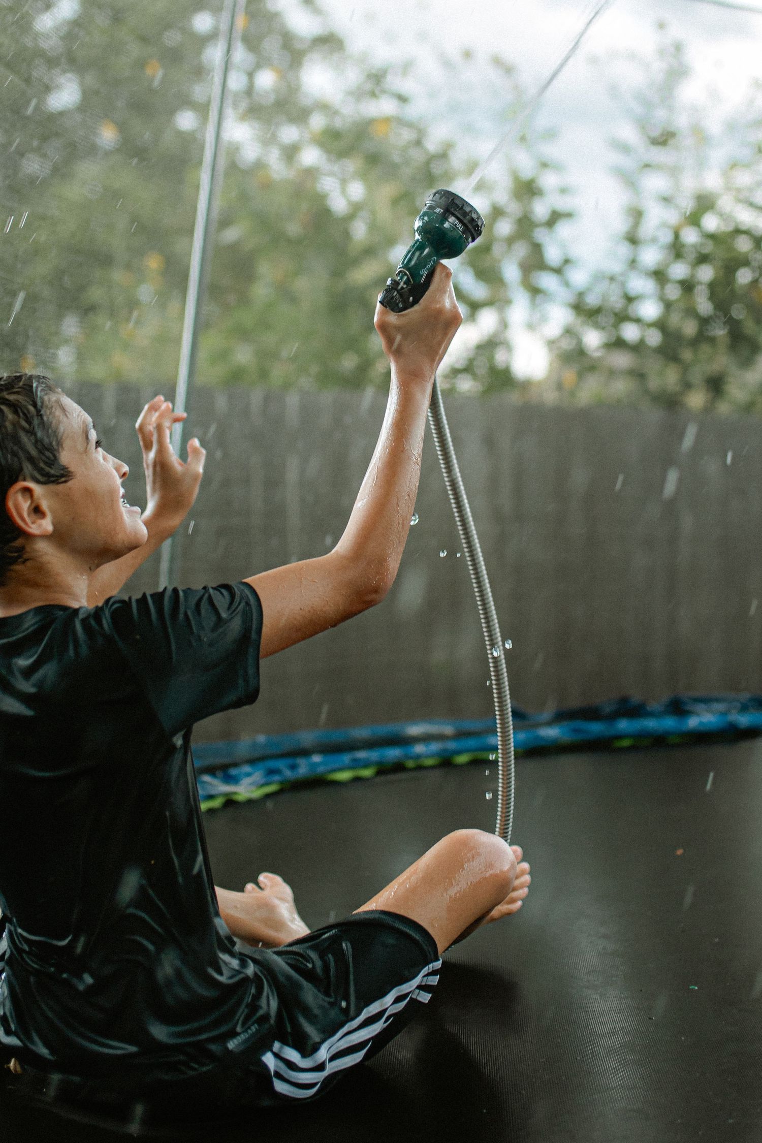 Sequence showing backyard trampoline jumping movements against a dark fence background. In-Home Photography Liz Perez
