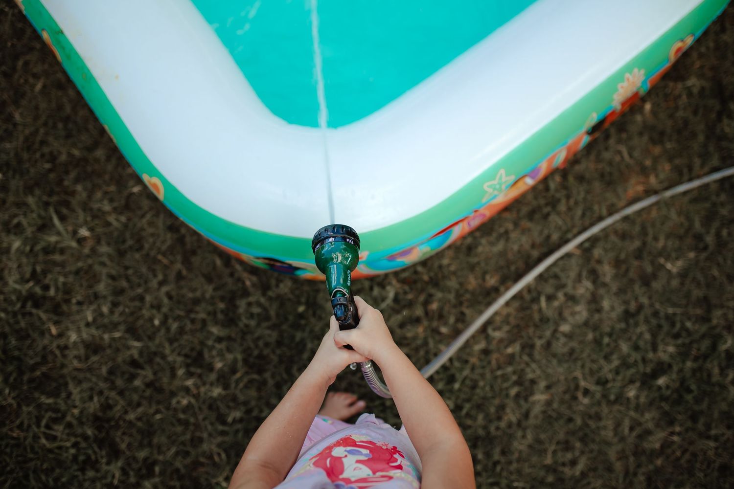 A child playing in the backyard pool. In-Home Photography Liz Perez