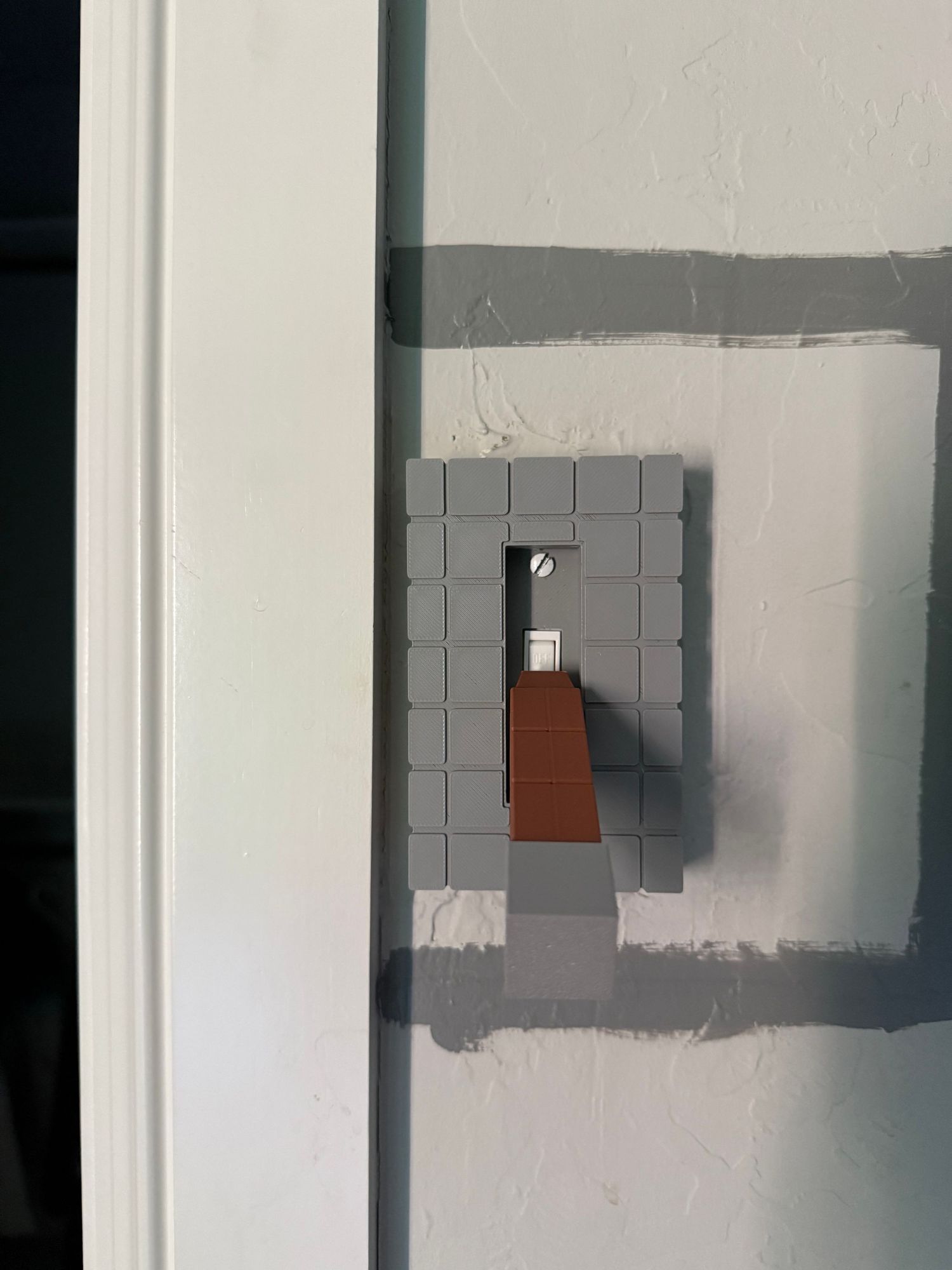 Close-up photos of light switch plates being painted white to match a wall's color. In-Home Photography Liz Perez