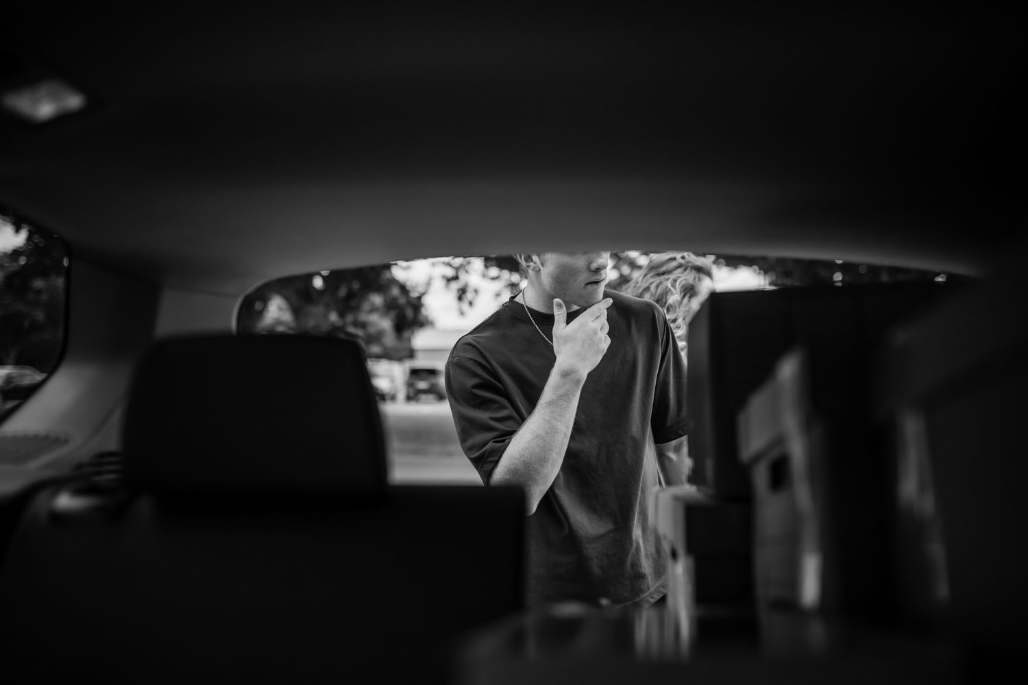 View through car window of someone loading items. In-Home Photography Liz Perez