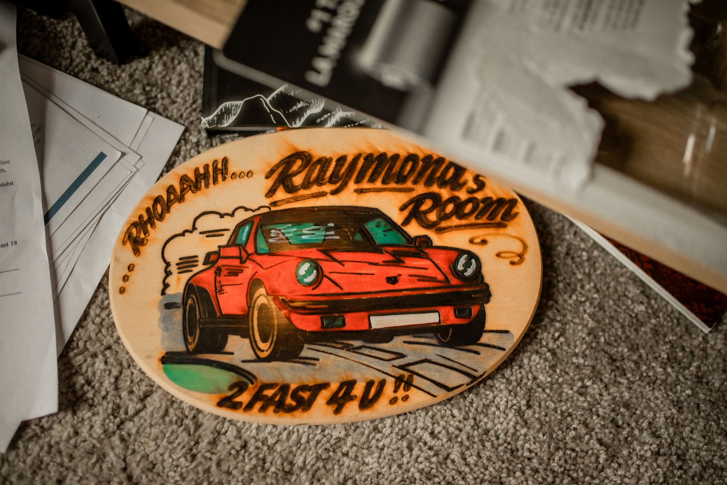 Vintage car designs shown on decorative wall art piece on the floor of his childhood room.