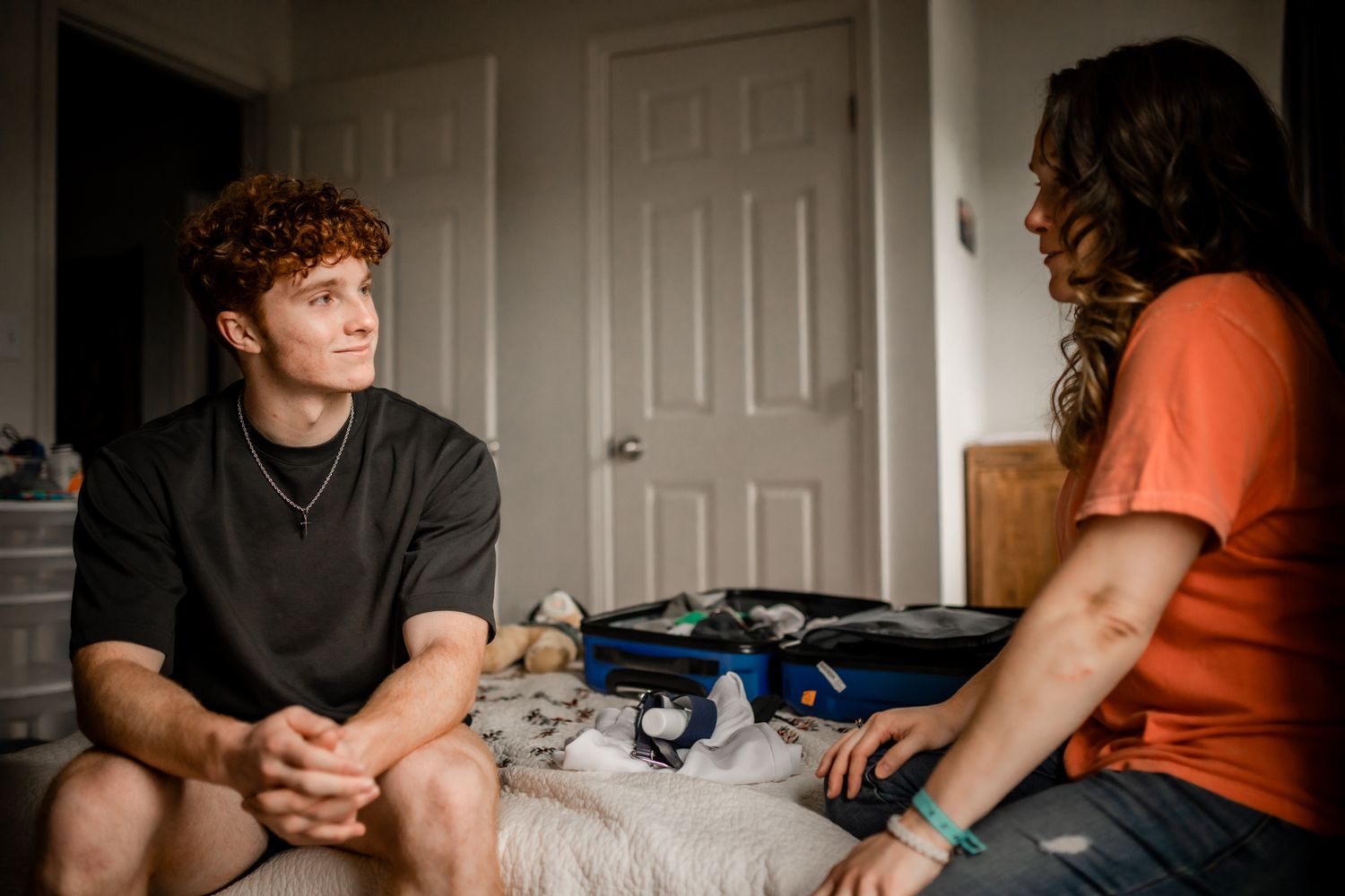 Two people engaged in conversation while sitting in a bright room.