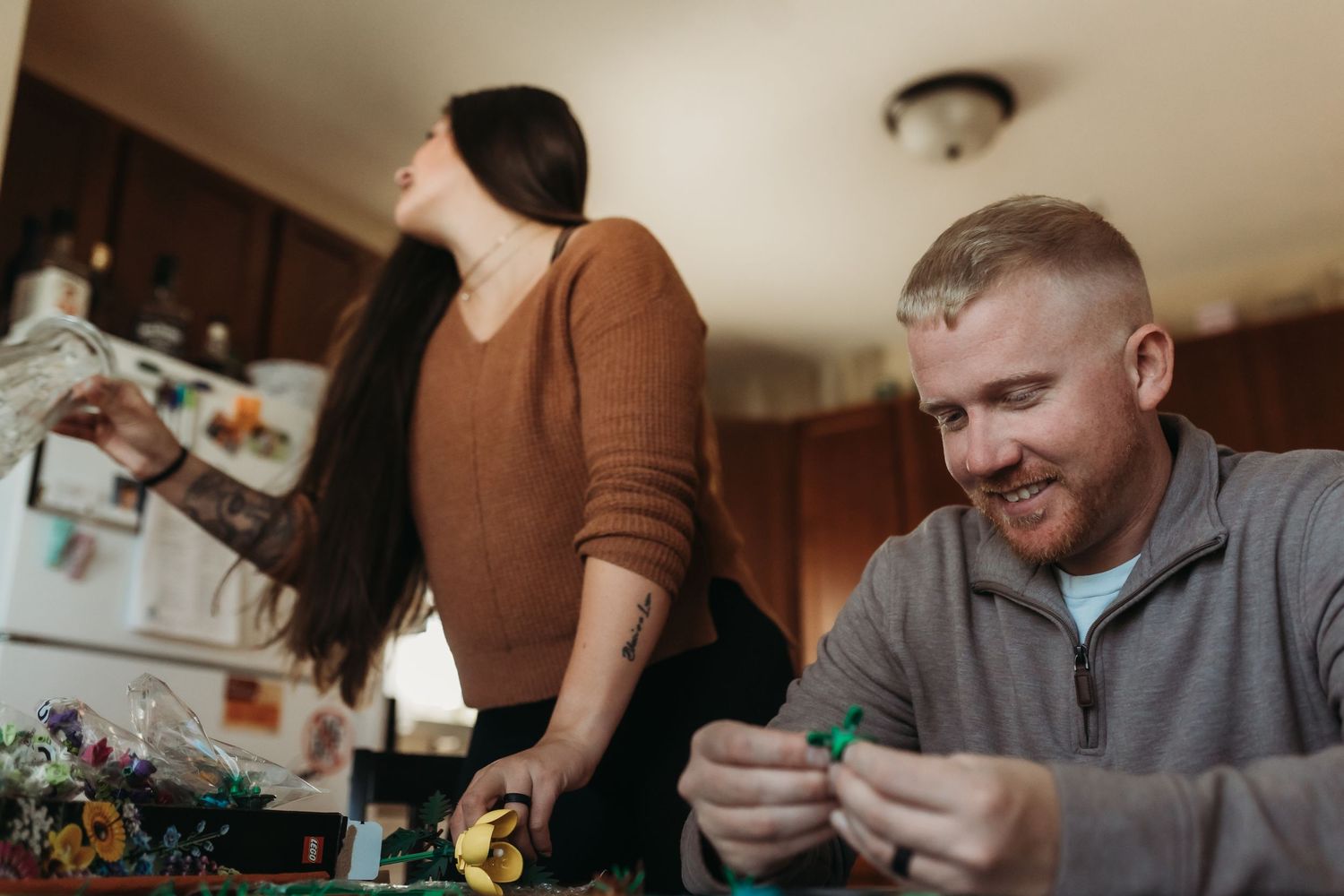 Two people enjoying a relaxed moment in a cozy kitchen while looking at something together.