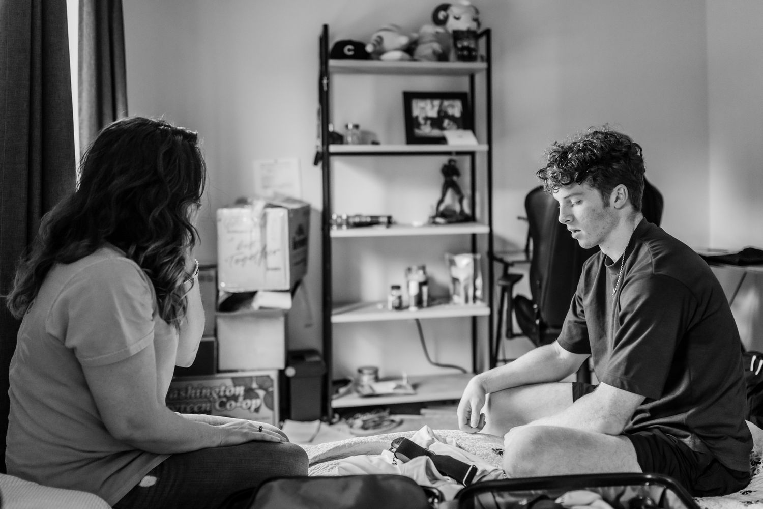 Two people share a study space while sitting at a desk near a window.