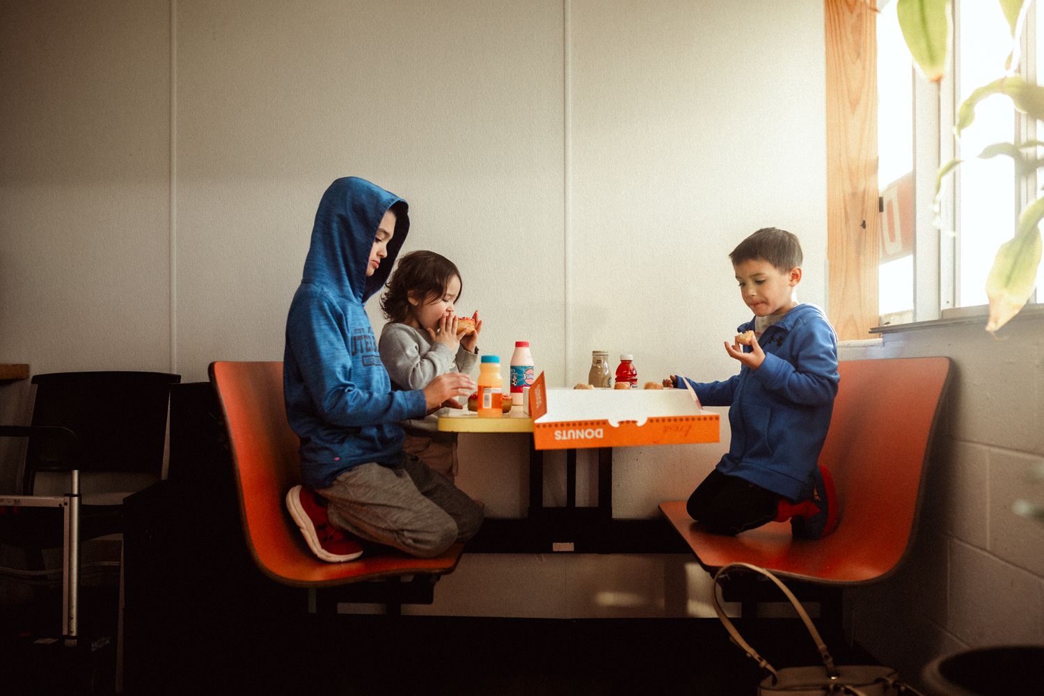 Family enjoying a meal together at an orange booth in a casual dining restaurant.