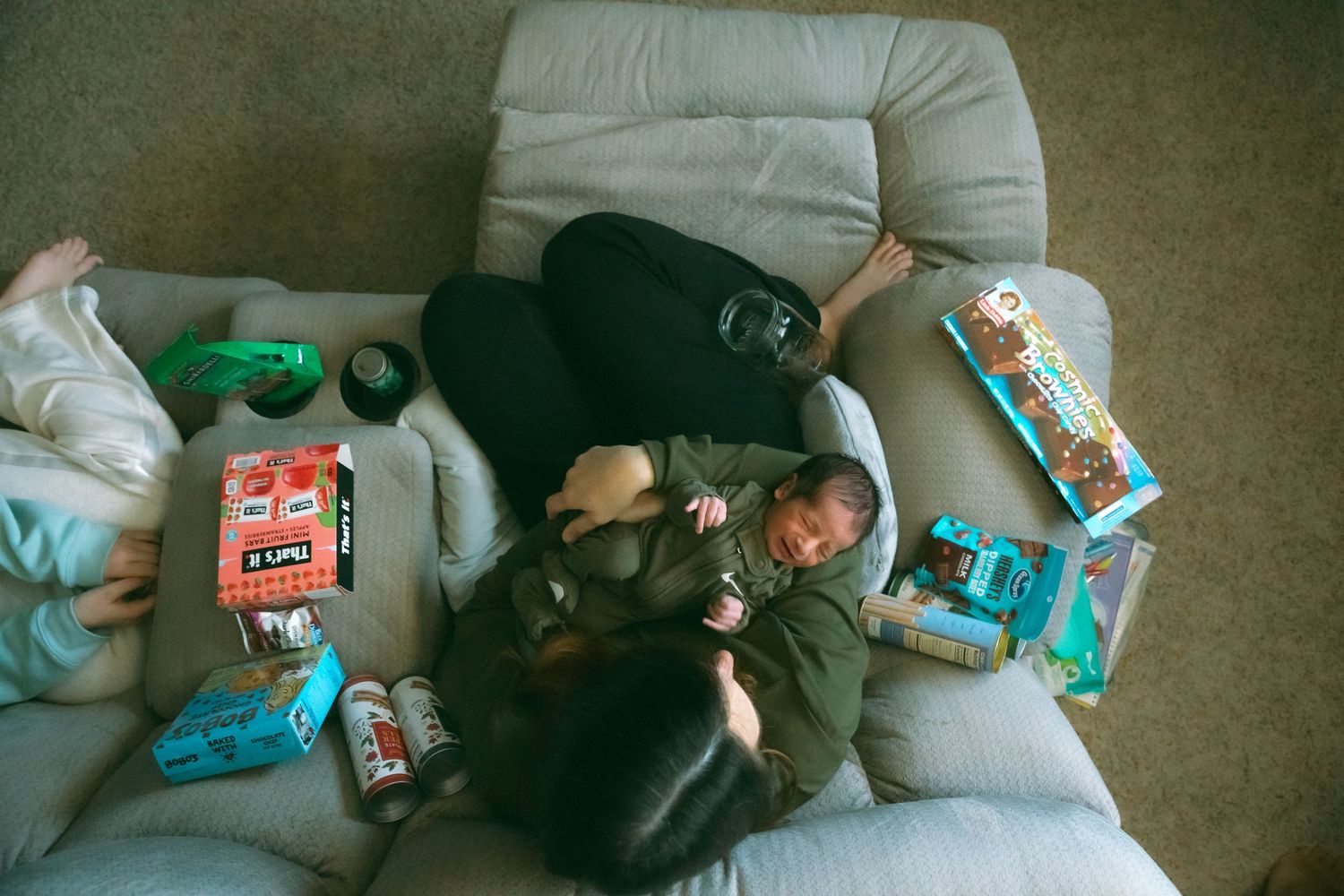Children relaxing on floor cushions while playing with electronic devices.