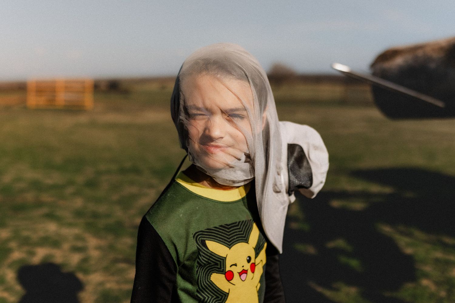 Person wearing a yellow Pokemon t-shirt skating outdoors at a park.