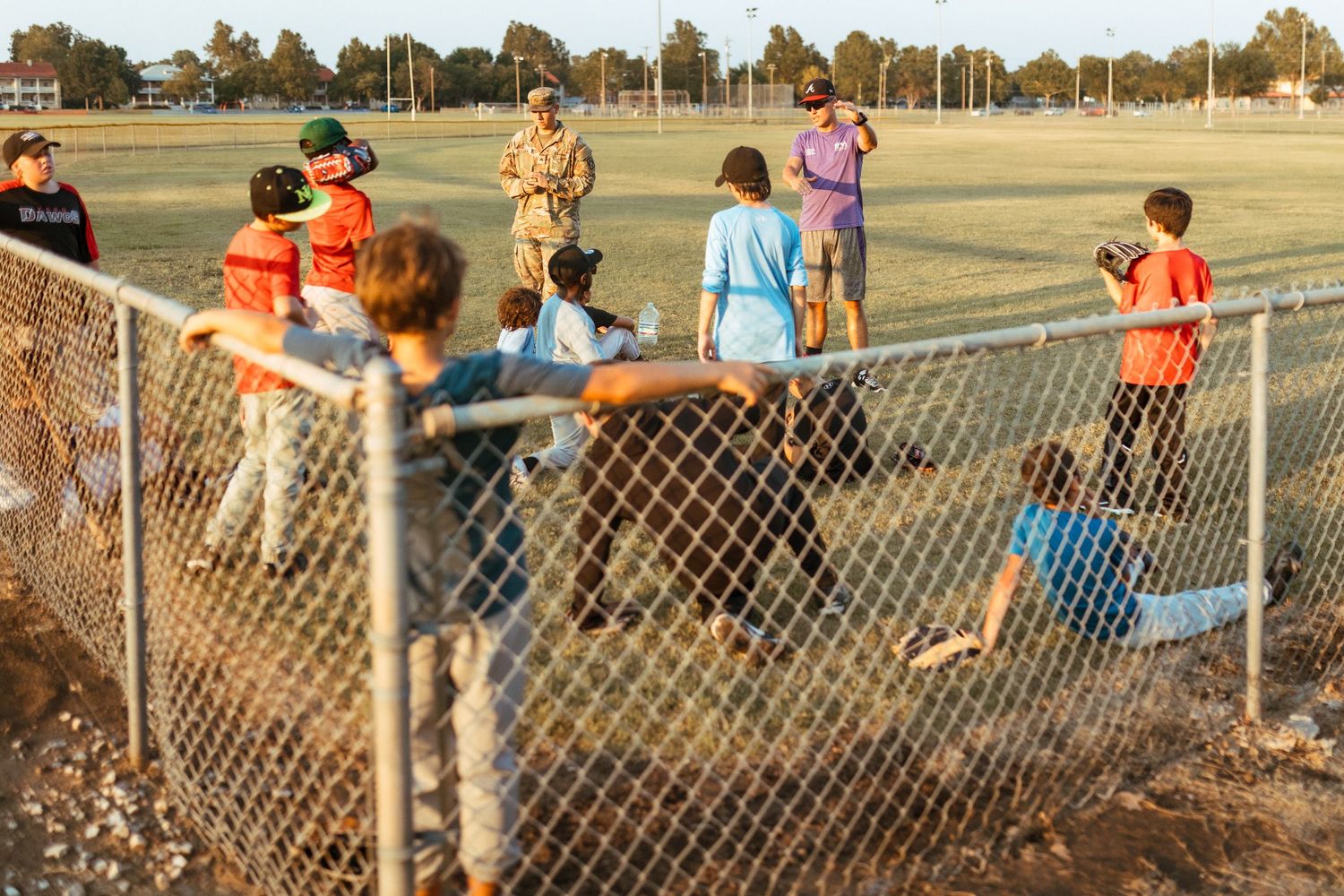 Children and spectators gathered along the chain link fence watching a youth sports game on an autumn afternoon.
Oklahoma Documentary Photog
