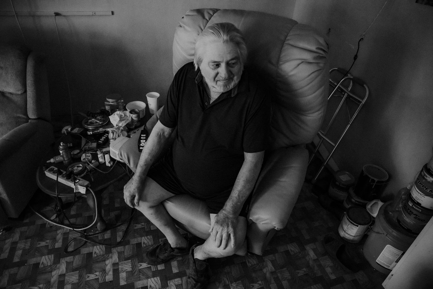 Black and white portrait of someone relaxing in a leather armchair.