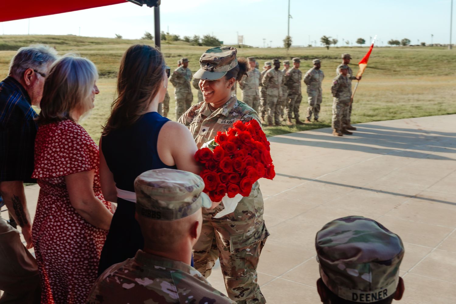 Military service members greet loved ones during an emotional homecoming ceremony outdoors.