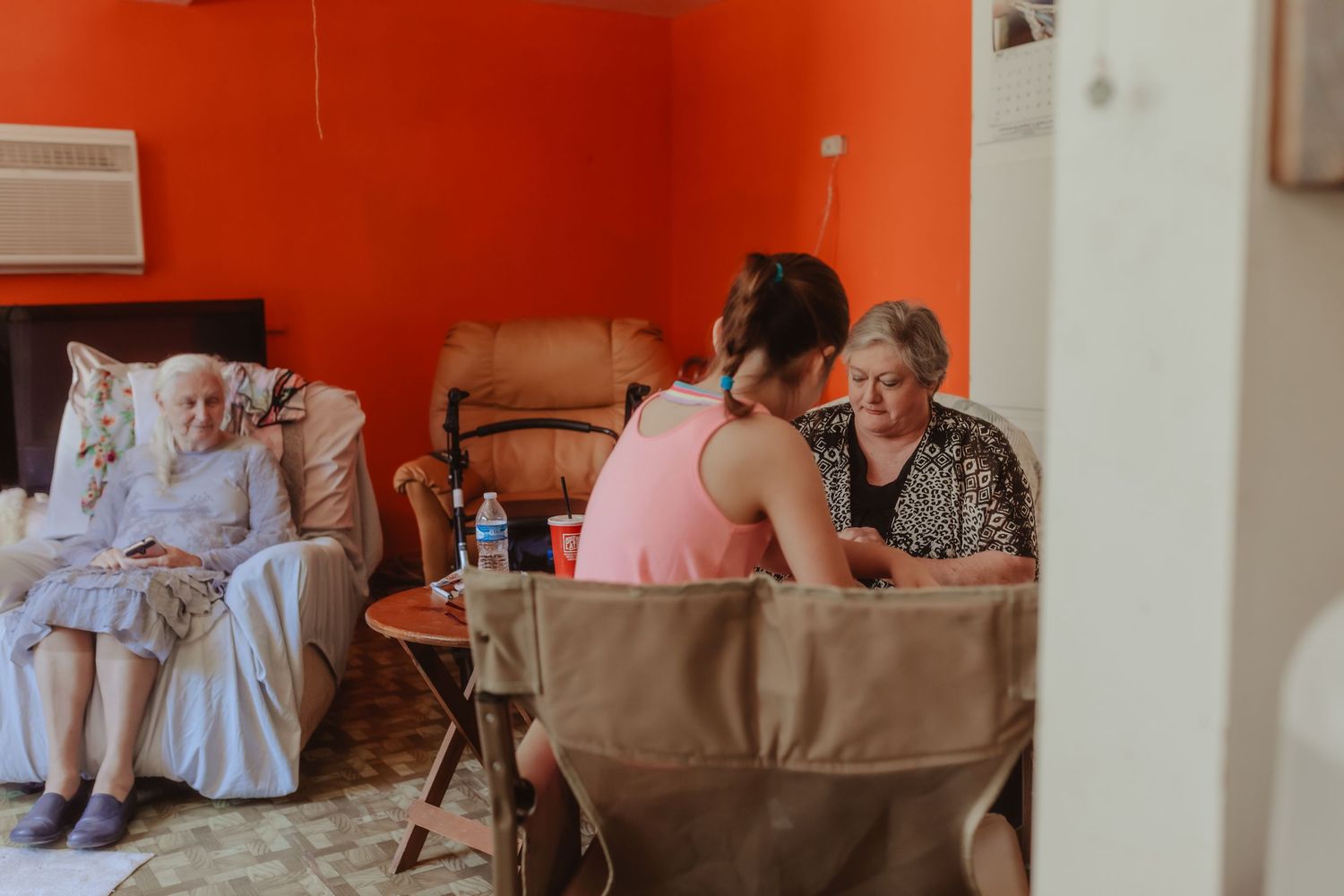 Indoor gathering space with orange walls and white chair coverings.