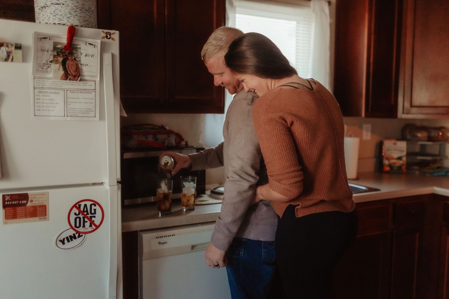 Someone looking into an open refrigerator in a kitchen.
