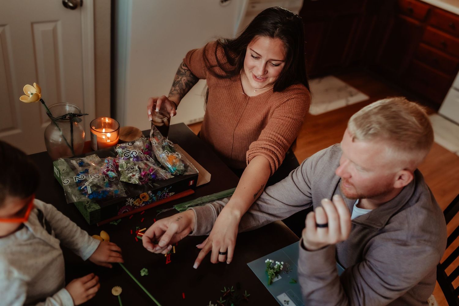 People playing a game together at a table with warm lighting.