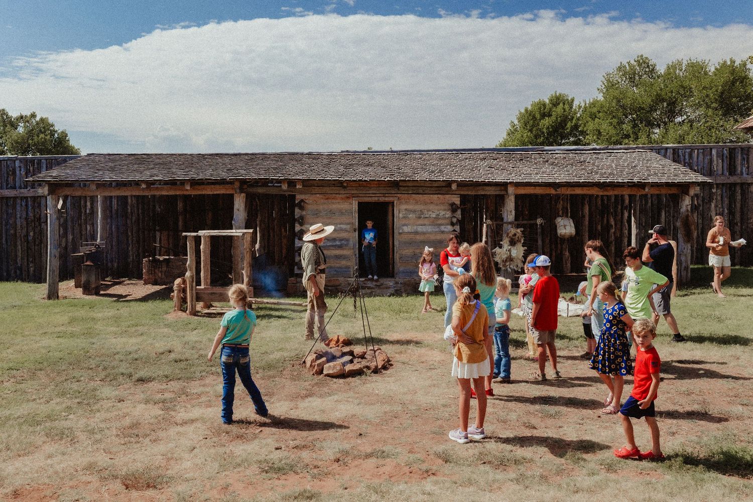 Historic fort buildings and visitors exploring the grounds of Great Plains Museum, Photography by Liz Perez Oklahoma Documentary  Photgraphe