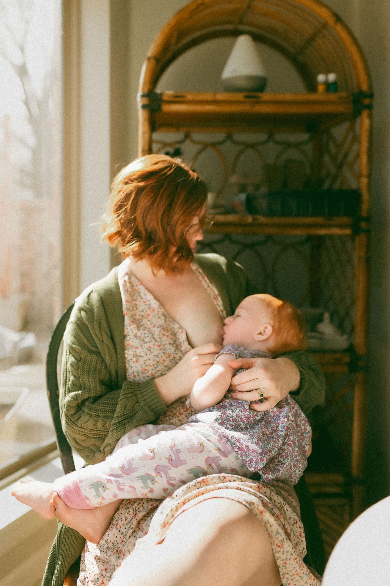 A tender moment captured in a sunlit room with a floral dress and green jacket.
