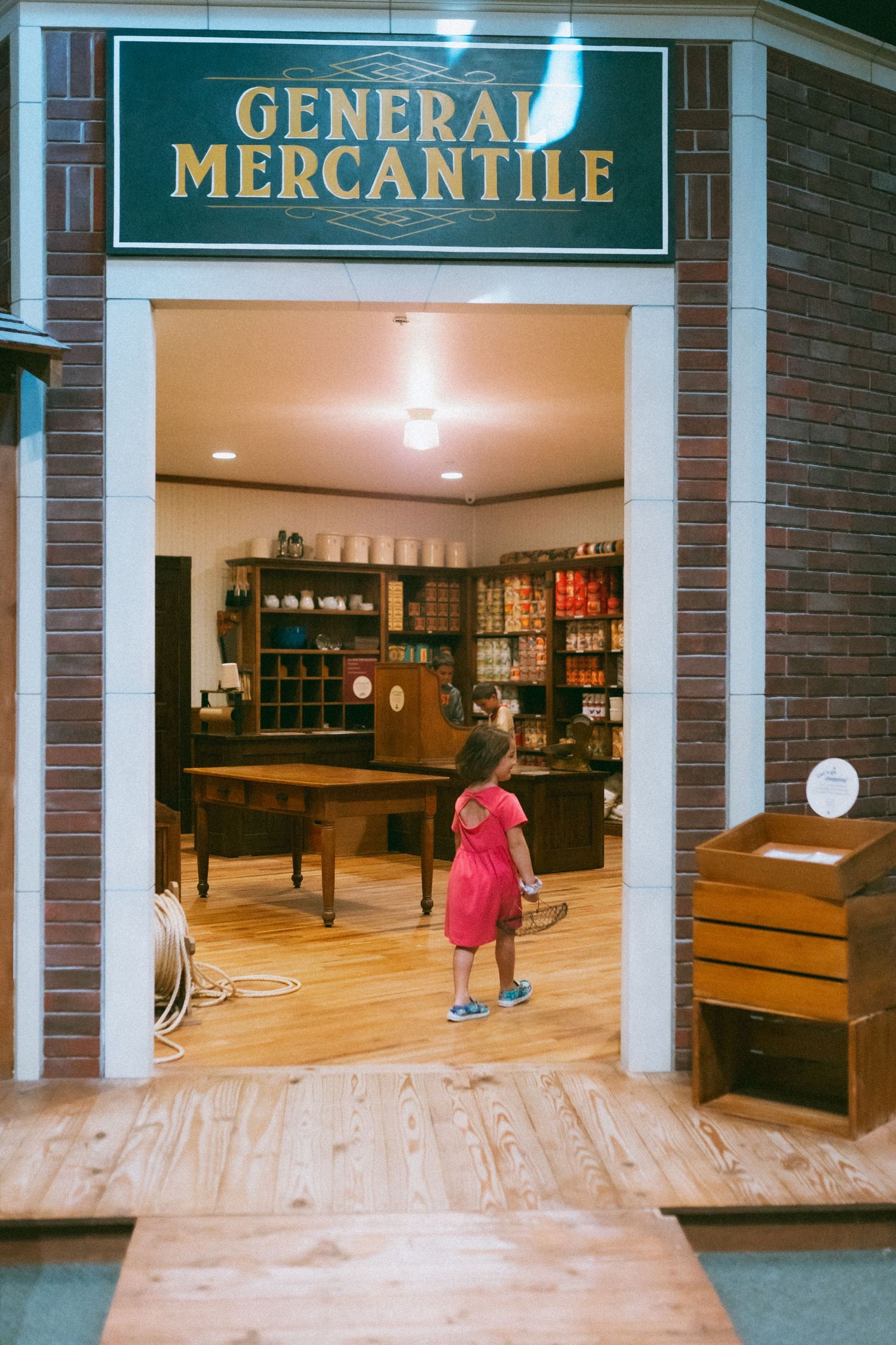 Wide view of a vintage general mercantile store interior with wood floors and exposed beam ceiling.