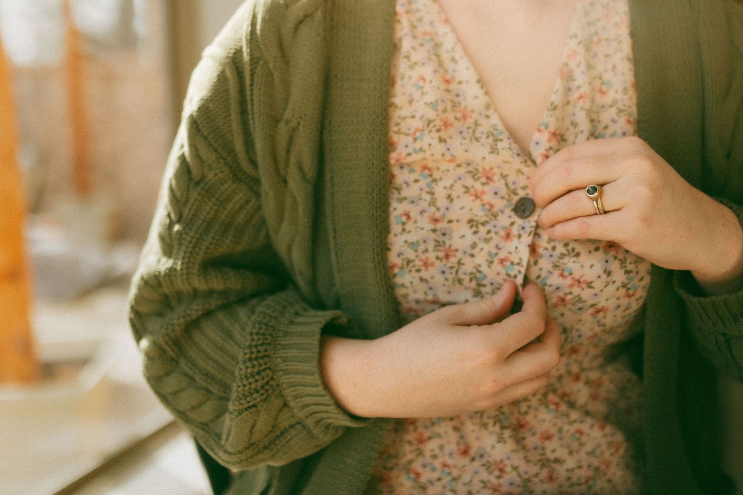 Collage of five photos showing someone wearing a green jacket holding a floral dress against a warm-toned background.