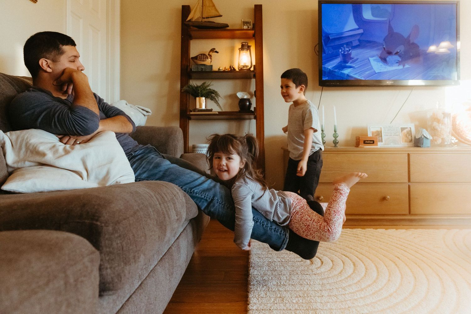 Living room interior with a TV mounted on the wall and comfortable seating.