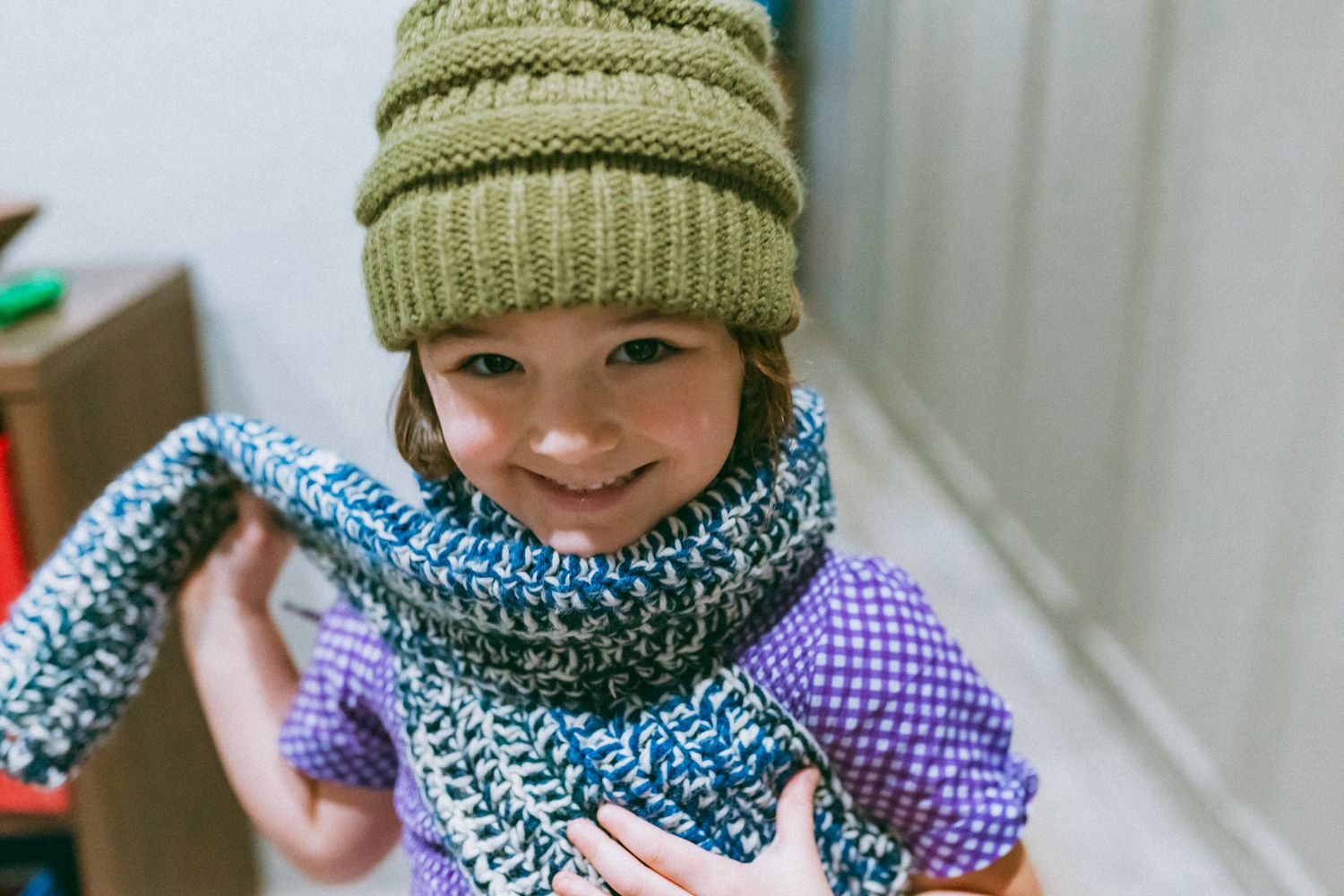 A cozy winter scene with green knit hats and blue scarves.