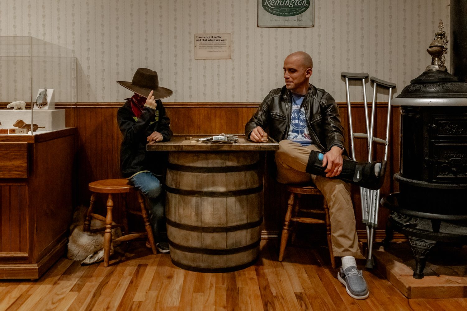 A casual conversation around a wooden barrel in a rustic indoor setting with antique decor.