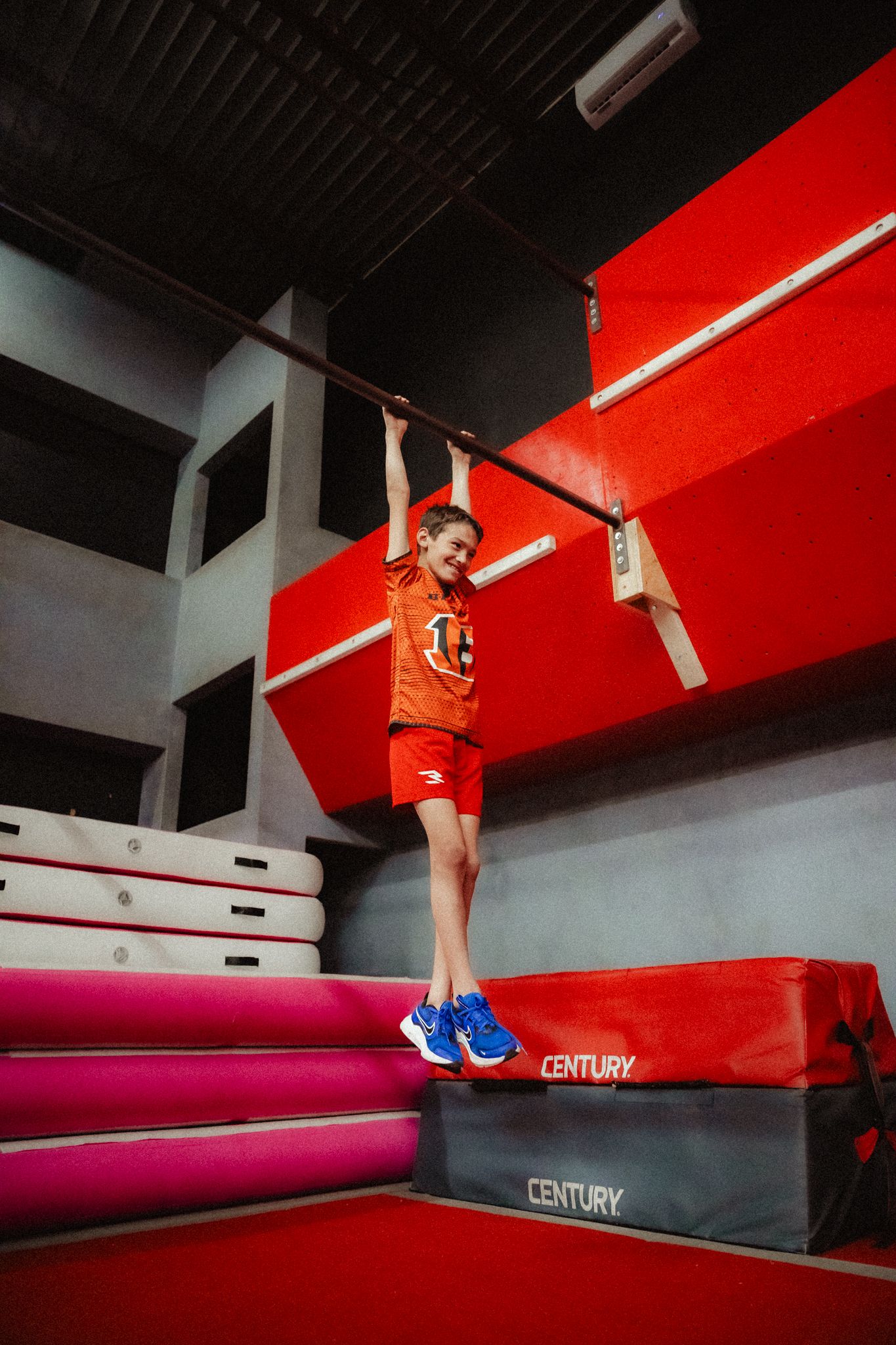 A sequence of athletic movements on red and pink gymnastics equipment.