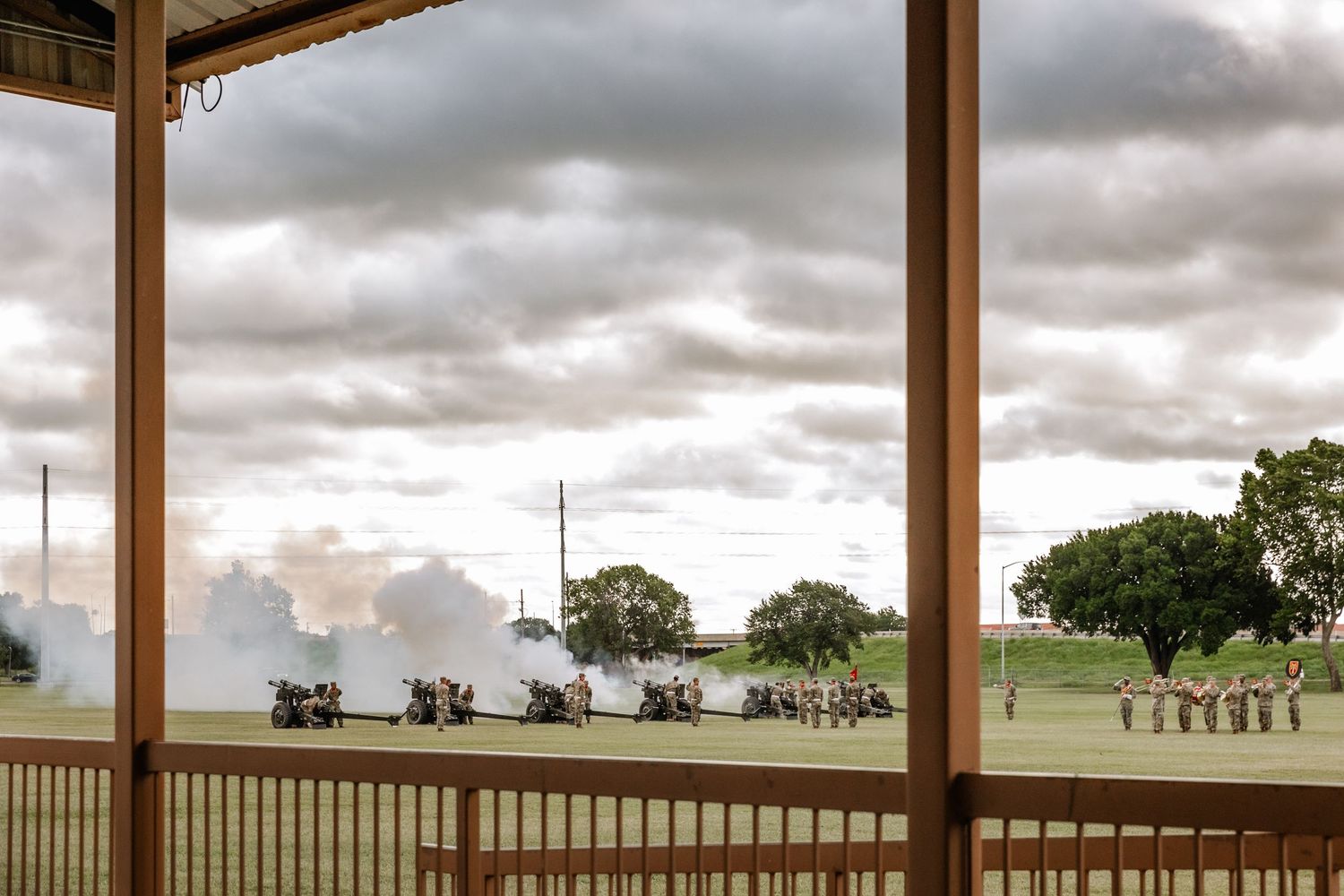 View from a covered porch overlooking a misty field with lawn chairs and trees under dramatic cloudy skies.