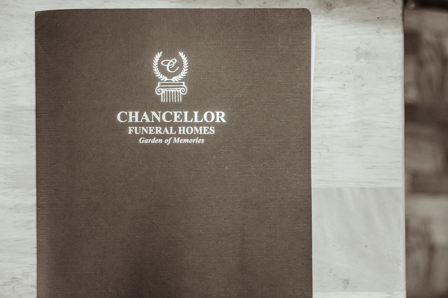 Close-up of Chancellor Funeral Homes logo and text on brown cover material.