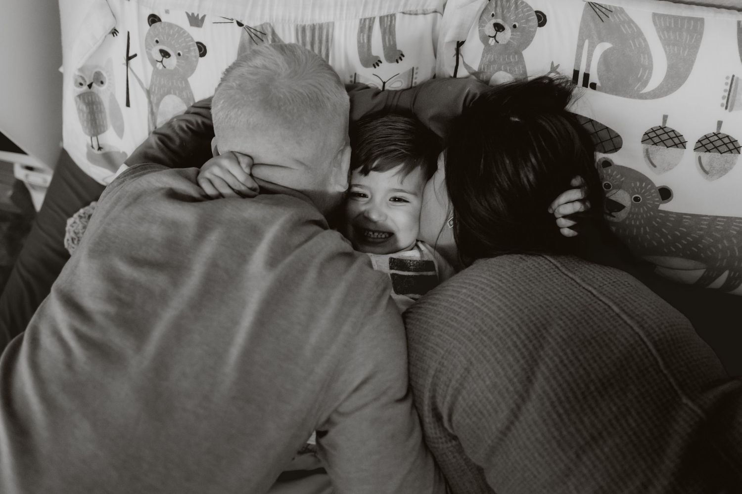 Sweet bedtime scene with parent and child lying together under soft lighting.