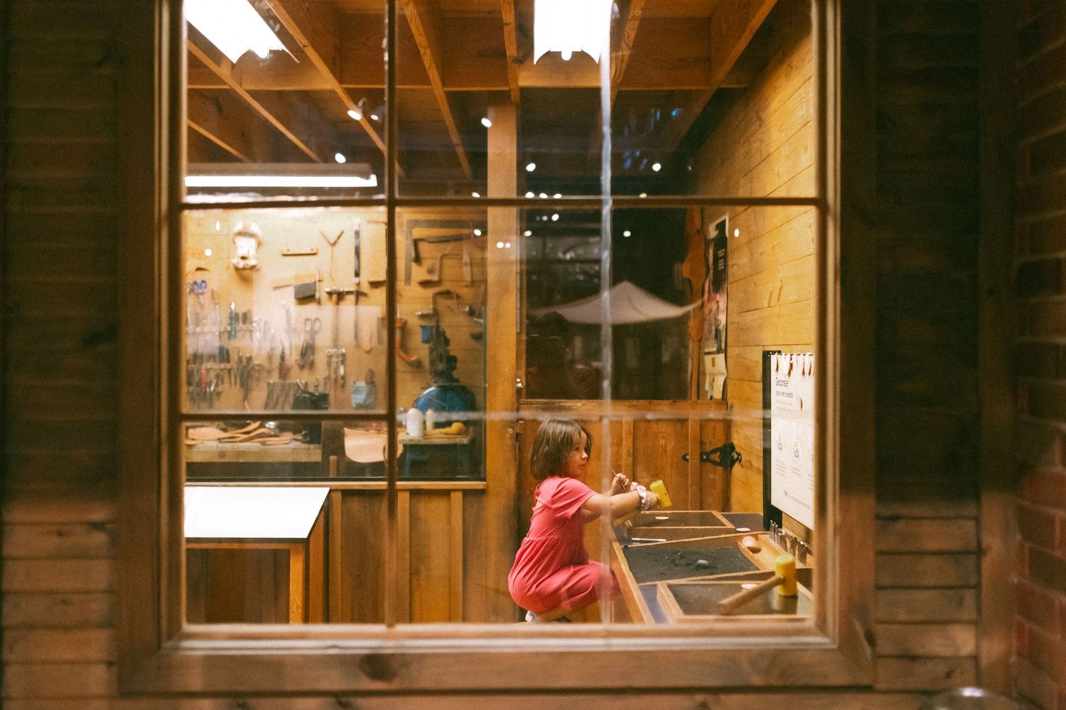 Illuminated wooden retail store windows display a cozy interior ambiance at night.