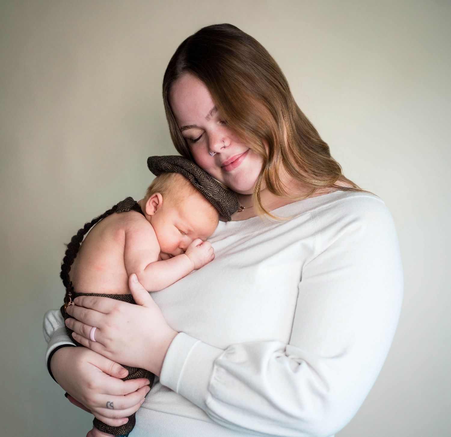 A mom and baby cuddle in close during their newborn session near Whiteman AFB, MO