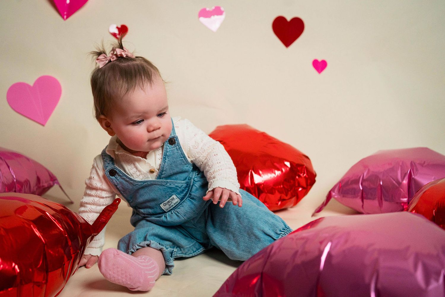 A baby plays with balloons during a holiday mini session located in the photographers studio in Warrensburg