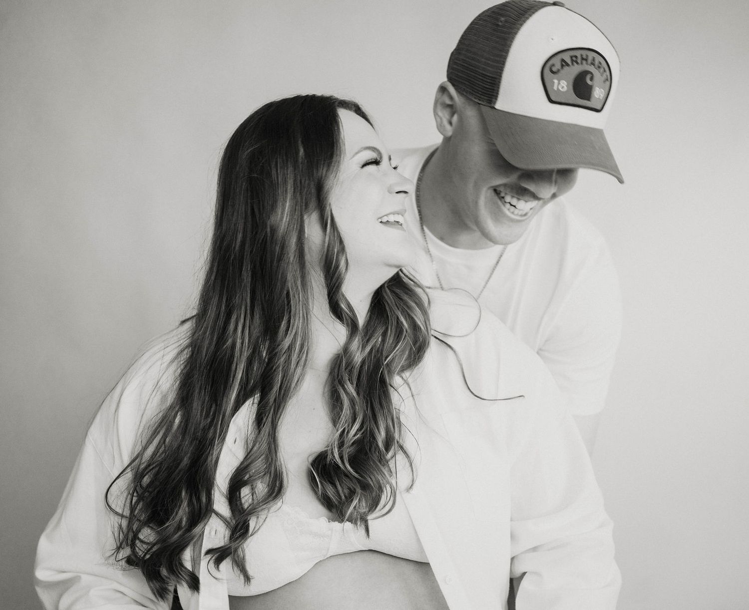 a couple laughs in their maternity session in Knob Noster, MO